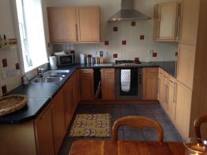 a kitchen with wooden cabinets and a sink and a stove at Abbey View in Kelso