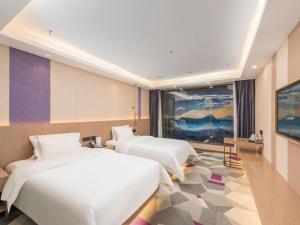a hotel room with two beds and a television at Lavande Hotel Foshan Shunde Daliang Qinghuiyuan Shihu Road in Shunde +290 photos