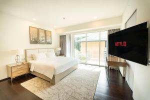 Un dormitorio con una cama y un televisor de pantalla plana. en Serenity Saigon Sky Villas - Free One Way Airport Shuttle, en Ho Chi Minh