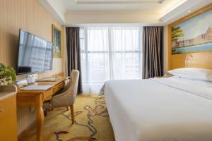 a hotel room with a bed and a desk at Vienna Hotel Kunming Beijing Road Chuanxin Gulou Metro Station in Kunming