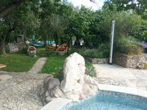 a swimming pool with a rock in a yard at KATY&MLADEN in Baška