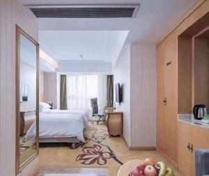 una habitación de hotel con una cama y un espejo en Vienna Hotel Anhui Taihe Baitai Xingma International, en Taihe 126 fotos más