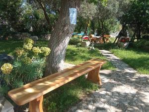 a wooden bench sitting next to a tree at KATY&MLADEN in Baška