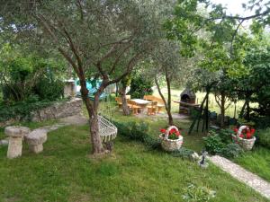 a garden with a table and chairs and trees at KATY&MLADEN in Baška