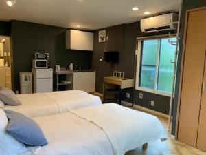 a hotel room with two beds and a kitchen at HOSTEL LUND I -Oimachi- in Tokyo