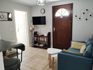 Mauvezin-sur-GupieにあるLa Fontaine du Pas, dans Villa, 2 chambres Piscine 11x5の青いソファとテレビのあるリビングルーム