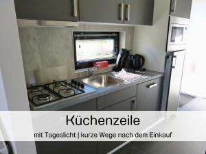 Nhà bếp/bếp nhỏ tại Ferienhaus 55 am Wasser Olburgen - perfekt für Familien - mit Freibad, Sauna, Restaurant und Spielplatz