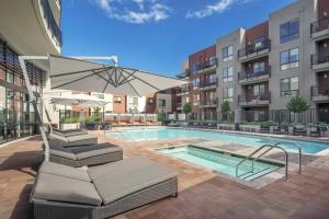 a swimming pool with a chair and an umbrella at Verve Mountain View in Mountain View