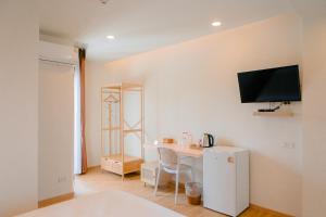 a room with a desk and a tv on the wall at Baan Cocoa Boutique Hotel in Natai Beach