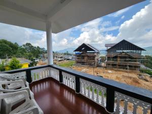 a balcony of a house under construction with chairs at Munnar Dreams Homestay For Kolukkumalai Tourists in Chinnakanal