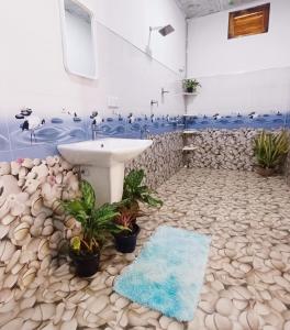 a bathroom with a sink and a rock floor at Salty Palm Villa in Arugam Bay