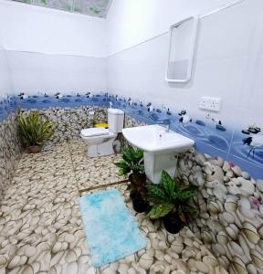 a bathroom with a sink and a toilet on a rock floor at Salty Palm Villa in Arugam Bay