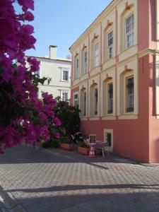 a pink building with a bench in front of it at Antik Ridvan Hotel in Çeşme +37 photos