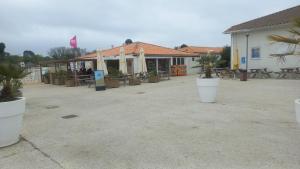 a patio with potted plants in front of a building at Mobilhome 602 in Les Mathes