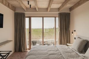 a bedroom with a bed and a large window at Hoeve De Hemel in Zuienkerke