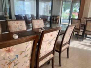 a dining room with a table and chairs with flowers at Rathna Residency in Tiruppattūr