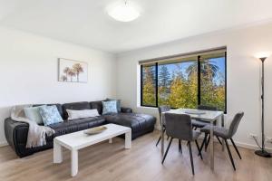 a living room with a couch and a table at Beachside Breakaway Glenelg South 200m to the Beach in Glenelg