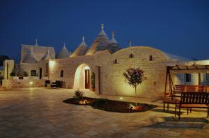 a large building with a courtyard at night at Trulli IsAgo in Locorotondo