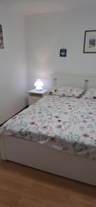a bedroom with a bed with a floral bedspread at Apartman Legac in Starigrad