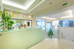 a woman sitting at a counter in a lobby at Adriatic Deluxe Apartments in Dubrovnik