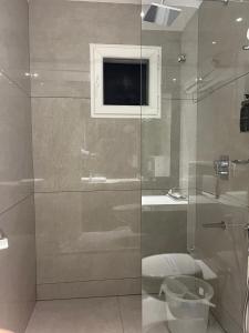 a bathroom with a glass shower with a toilet and a sink at Rathna Residency in Tiruppattūr +36 photos