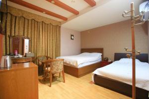 Postel nebo postele na pokoji v ubytování Monaco Hotel Jeju