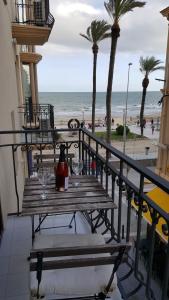 a table on a balcony with a view of the beach at Estrella Primero De Mayo in Sitges