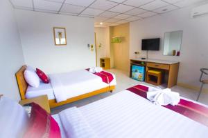 ein Hotelzimmer mit zwei Betten und einem Flachbildfernseher in der Unterkunft Central Place Hotel in Ban Thai Wat Khot + 31 Fotos