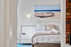a bedroom with a bed and a picture of a boat at Nautilus Beach Resort by Charlesworth in Coffs Harbour