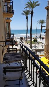 balcón con vistas a la playa y a las palmeras en Estrella Primero De Mayo, en Sitges
