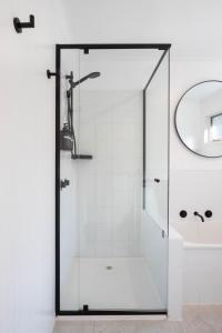 a shower with a glass door next to a sink at La Boheme Tootgarook in Tootgarook