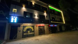 a building with a sign on the side of it at night at Hostal El Bosque in Huánuco