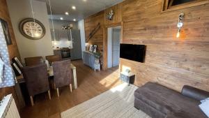 a living room with a wooden wall and a dining room at Tramonto sulla Pista a Prato Nevoso in Prato Nevoso