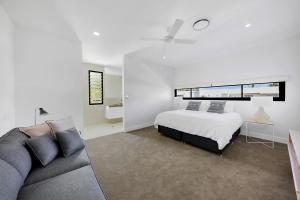 Un dormitorio blanco con una cama y un sofá. en Callula Noosa, en Noosa Heads 23 fotos más