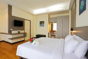 a bedroom with a large white bed and a television at GreenView Boutique Hotel in Sungai Kolok