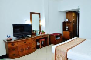 a bedroom with a bed and a television on a dresser at Hotel Tarakan Plaza in Tarakan