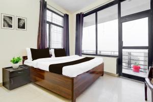a bedroom with a large bed and large windows at Collection O Bhowali Nainital Near Graphic Era Hill University in Nainital