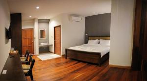 a bedroom with a bed and a wooden floor at Phumin Place Hotel in Nan