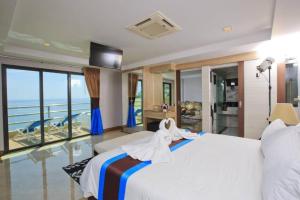 a bedroom with a bed with a view of the ocean at Blue Wave Hotel Hua Hin in Hua Hin