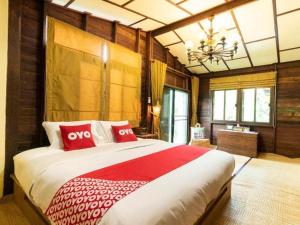 a bedroom with a large bed with red pillows at OYO 750 Baan Suan Ampond in Bangkok