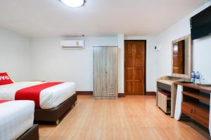 OYO 874 Wong Ruean Thai Resort في Ban Saen Muang: غرفة فندق بها سرير ومكتب +33 صورة