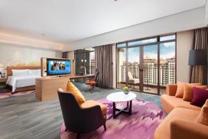 海口市にあるHampton by Hilton Nanhai Haikouのベッドとテレビがあるホテルの部屋