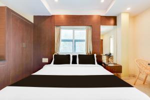 a bedroom with a large bed and a window at Super Townhouse Dwarka Nagar Near Ramatalkies in Visakhapatnam