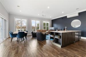 una cucina e un soggiorno con tavolo e sedie di 'Barton House' - Ideal Location Stroll to CBD a Orange