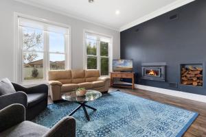 un soggiorno con divano e camino di 'Barton House' - Ideal Location Stroll to CBD a Orange