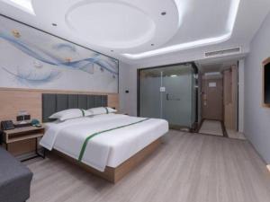 a bedroom with a large white bed and a couch at GreenTree Inn JiangSu Changzhou Lijia Town Wujin Road Business Hotel in Changzhou