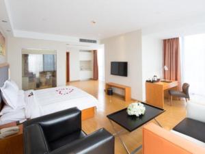 a hotel room with a bed and a couch at Warmly Hotel Suzhou Shuanghuwan in Suzhou