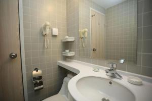 a bathroom with a sink and a mirror and a phone at Jinjiang Inn Pingliang West Railway Station Xuanhe New City in Pingliang +121 photos