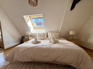 a bedroom with a large bed with white sheets and pillows at Charme et Confort, plein centre in Obernai