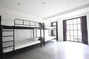 a room with two bunk beds and a window at L22 HOSTEL in Bangkok